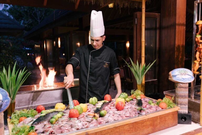 Canareef Resort chef preparing a fresh seafood buffet featuring locally sourced fish from Addu Atoll fishermen, Maldives
